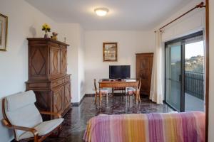 a living room with a television and a desk with a chair at Da Ernestina in Imperia