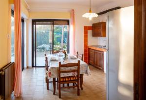 a dining room with a table and a kitchen with a refrigerator at Da Ernestina in Imperia