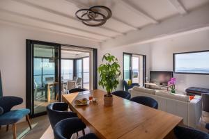 a living room with a wooden table and chairs at Villa 4 Etoiles vue sur les Iles d'Or Carqueiranne Sea and Mountain Pleasure Villa vue mer 180 in Carqueiranne