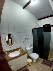 uma casa de banho com um WC, um lavatório e um espelho. em Chalés dos Carneiros em Tamandaré