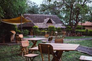 a group of tables and chairs in front of a house at Patamu Restaurant & Lodge in Karatu