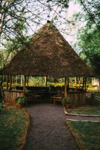 a large straw hut with tables and chairs under it at Patamu Restaurant & Lodge in Karatu