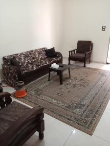 uma sala de estar com um sofá, uma mesa e cadeiras em الشقة العائلية الحديثة em Amã