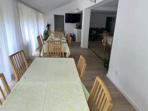 a dining room with a long table and chairs at Pensiunea Marydor in Gârda de Sus