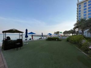 a resort with a green lawn next to the beach at Sea-View Studio with Beach Access in Ras al Khaimah