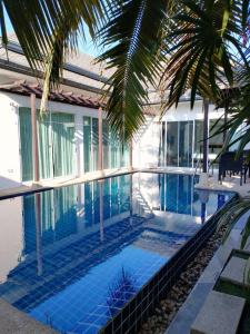 a swimming pool in front of a house at Kamala pool Villa in Kamala Beach