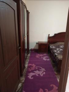 una habitación con una alfombra púrpura junto a una puerta en الشقة العائلية الحديثة, en Amán
