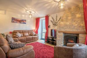 a living room with a couch and a stone fireplace at Wern-Fawr in Betws-y-coed
