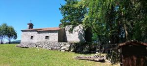 a stone building on a hill with a tree at Casa Mersino in Lindar