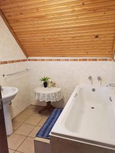 ein Badezimmer mit einer Badewanne und einem Waschbecken in der Unterkunft Hill Billys Selfcatering in Winterton