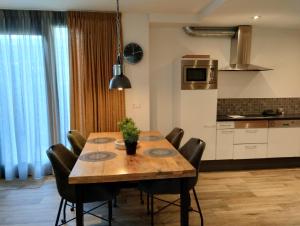 a dining room table with chairs and a kitchen at Aan't Strand Bed by the Sea Adults only in Westkapelle