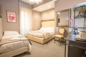 ローマにあるRometobeのベッド2台と鏡が備わるホテルルームです。