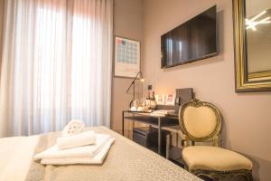 a room with a desk and a bed with towels at Rometobe in Rome