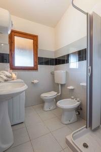 uma casa de banho com um WC, um lavatório e um chuveiro em Apartments in San Teodoro 42817 em San Teodoro