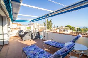 a balcony with chairs and a table on a roof at Villa Jazmin in Fuengirola
