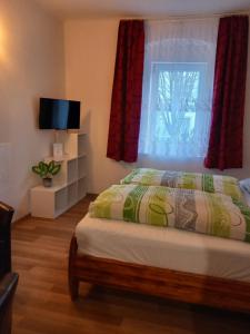 a bedroom with a bed and a window with red curtains at Szép-Lak Makó in Makó