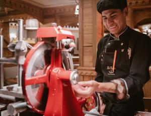 Un homme dans une cuisine travaillant sur une machine dans l'établissement Hôtel Alpen Ruitor, à Méribel