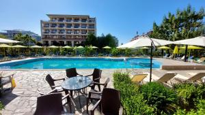 a swimming pool with chairs and tables and umbrellas at Diamond Palace in Sunny Beach