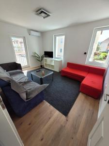 uma sala de estar com um sofá vermelho e uma mesa em Ferienwohnung und Monteurzimmer em Albstadt