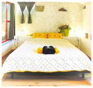 a bedroom with a bed with two pairs of shoes on it at Le Gîte des Cimes in Tulle