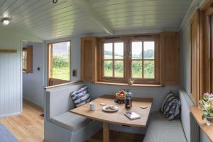 a tiny house with a table and chairs at Deer Lodge Shepherds Hut in Rowlands Castle