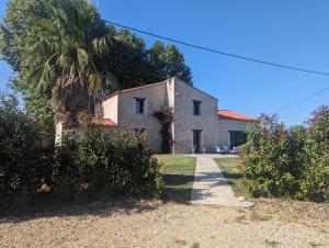 una casa con una palmera delante de ella en Mas Puig, en Saint-Génis