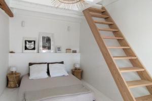 1 dormitorio con 1 cama y escalera de madera en Le Ramponnet, maison de village, 6 pers, en Menthon-Saint-Bernard