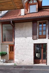 una casa con puertas y ventanas de madera. en Le Ramponnet, maison de village, 6 pers, en Menthon-Saint-Bernard