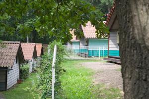 une clôture devant une maison avec une cour dans l'établissement Waldidylle - Bungalows an der Talsperre Kriebstein, à Kriebstein