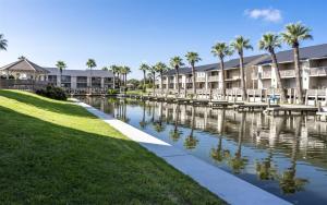 a canal in front of a building with palm trees at La Vida Buena in Rockport