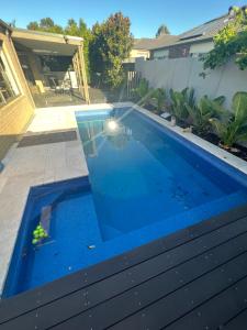 a swimming pool in a yard with a blue floor at Paradise pavilion hide away in Cranbourne