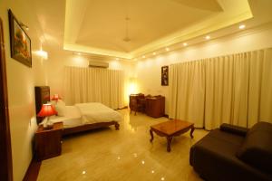 une chambre d'hôtel avec un lit et un canapé dans l'établissement TRAVANN, à Alappuzha