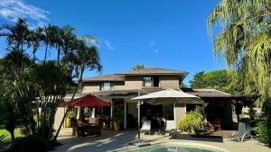 une maison avec une piscine en face de celle-ci dans l'établissement Villa Petit Tamarin : piscine bar et grand jardin tropical, à Tamarin