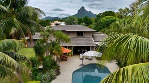 a house with a view of the mountain at Villa Petit Tamarin : piscine bar et grand jardin tropical in Tamarin