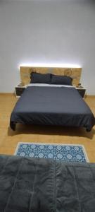 a bedroom with a bed with a blue blanket and a rug at Puerto Pesquero de Cariño in Cariño