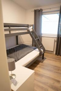 a bunk bed in a room with a window at Ferienwohnungen Haus am Königssee in Zetel