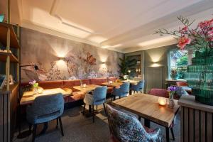 a restaurant with wooden tables and blue chairs at Hotel 't Kruisselt in De Lutte