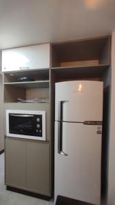 a kitchen with a white refrigerator and a microwave at Apto São Pedro, pertinho UFJF in Juiz de Fora