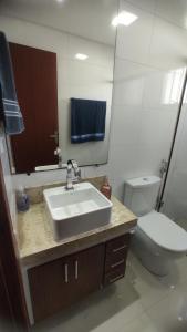 a bathroom with a sink and a toilet and a mirror at Apto São Pedro, pertinho UFJF in Juiz de Fora