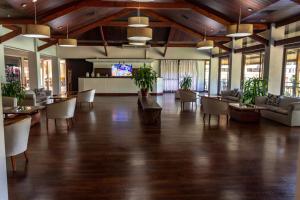 een grote kamer met een lobby met tafels en stoelen bij Hotel Raices Esturion in Puerto Iguazú