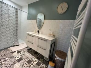 ein Bad mit einem Waschbecken und einem Spiegel in der Unterkunft Chez Marie-Jeanne 
