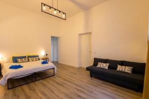 um quarto grande com uma cama e um sofá em Casa Lella Holiday Boutique em Palermo