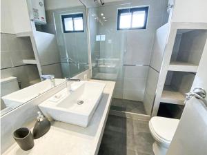 a white bathroom with a sink and a toilet at m a r ė a in José Ignacio