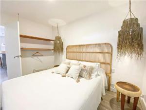 1 dormitorio con cama blanca y cabecero de madera en m a r ė a, en José Ignacio