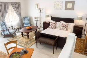 Sala de estar con cama y mesa en Hummingbird, en Pretoria