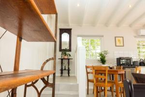 a kitchen and dining room with a table and chairs at Hummingbird in Pretoria +10 photos