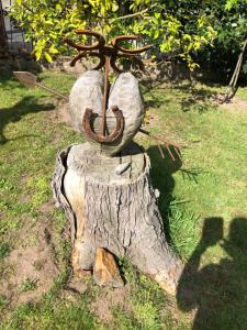 a metal statue of a tree stump with an anchor at Little Cottage auf 2 Etagen in Raben Steinfeld
