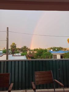 un arco iris se ve desde un balcón con sillas en La casa di Lucy, en Torre Ovo