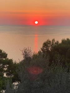a sunset over the ocean with the sun in the sky at La GEMMA di Orrico in Anacapri