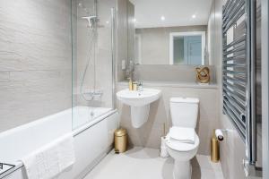 a bathroom with a toilet and a sink and a shower at Beautiful & Contemporary Hackney Retreat in London